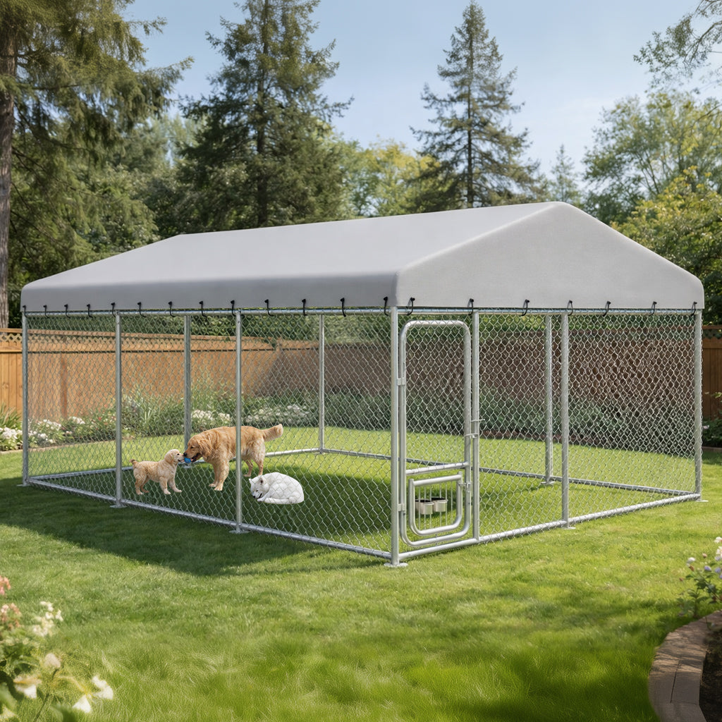 Outdoor dog kennel with all-weather resistant roof in grassy backyard, containing three dogs inside chain-link enclosure under trees and blue sky, from Garden & Outdoor pet supplies collection.