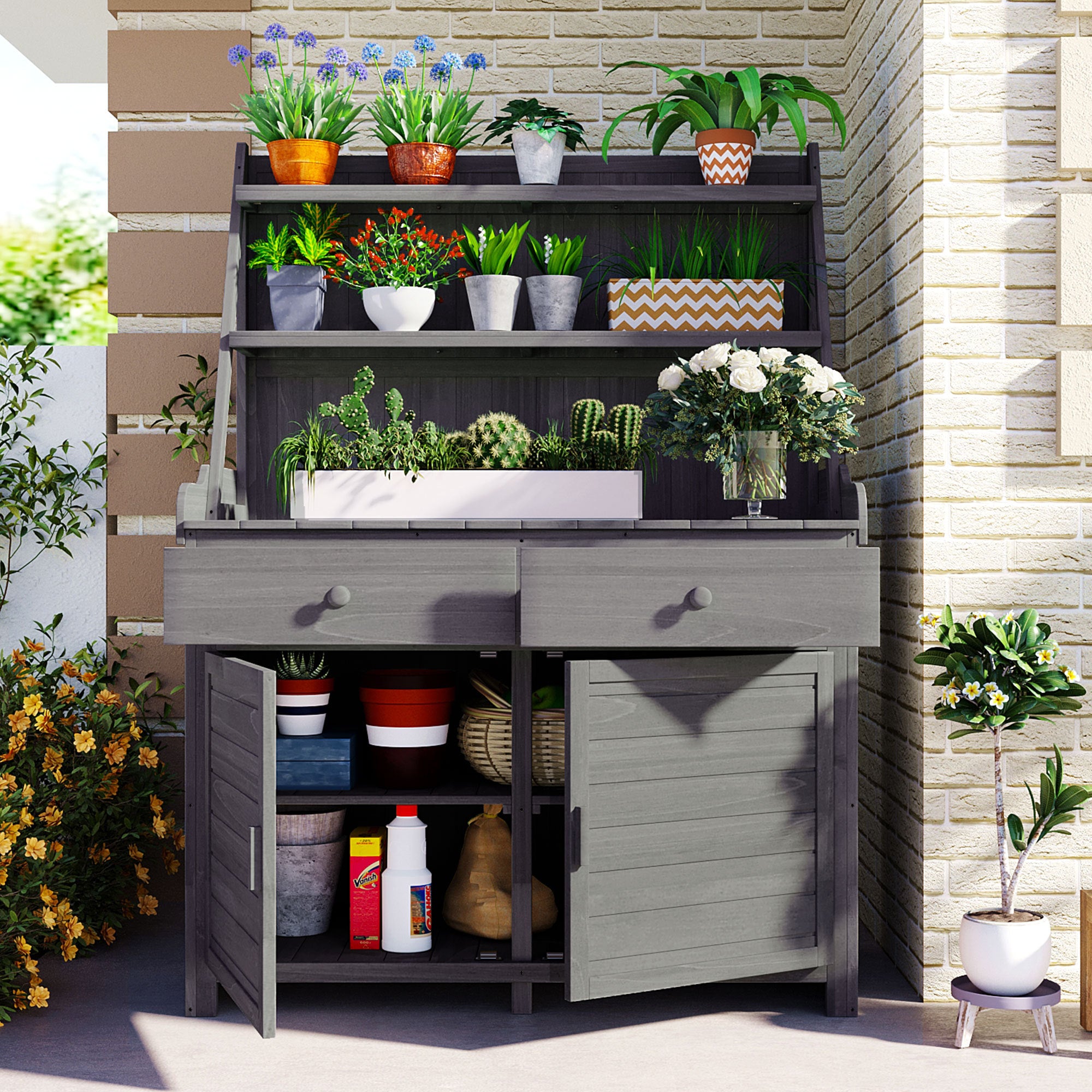 Garden potting bench with storage shelves, drawers, and cabinet in gray wood, holding various potted plants and gardening supplies, in an outdoor patio setting.