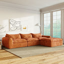 Orange chenille sectional sofa with integrated backrest and seat cushions, decorative edging, legless design, placed in bright living room with large windows and modern wall art.