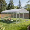 Outdoor dog kennel with all-weather resistant roof in grassy backyard, containing three dogs inside chain-link enclosure under trees and blue sky, from Garden & Outdoor pet supplies collection.