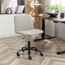 Gray ergonomic office chair with polyester fabric upholstery and adjustable height, positioned on a herringbone-patterned floor near a modern office desk with a laptop and decor.