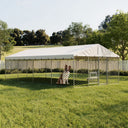 Large outdoor dog kennel with white canopy, galvanized steel frame, chain-link fencing, and a dog sitting inside on green grass in a fenced yard.
